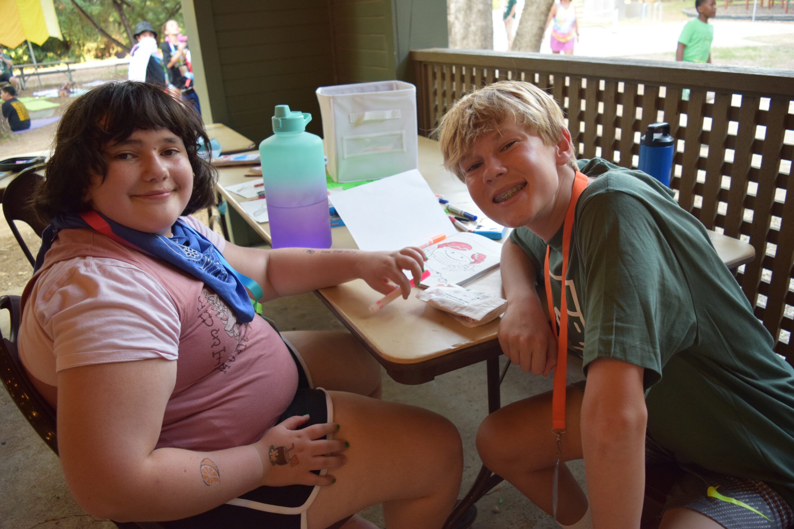 camper and volunteer at a table